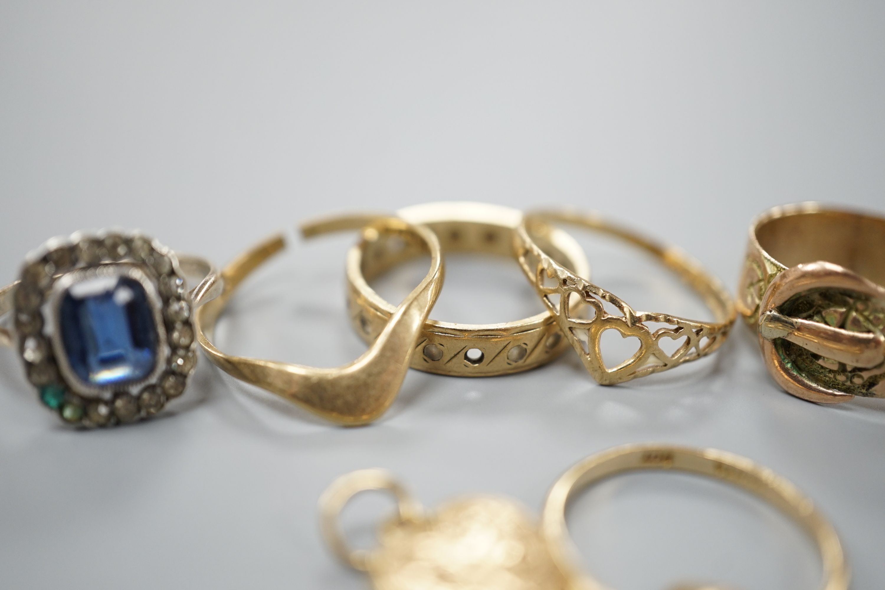 Four assorted 9ct gold rings, a 9ct gold heart pendant and a 9ct and paste set ring, gross 8.3 grams, an Edwardian 18ct gold ring, 4.4 grams and a yellow metal ring, 4 grams.